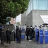 Turkish anti-riot police officers stand at the bottom of the building during a police raid at the headquarters of pro-opposition Halk TV in Istanbul, on October 14, 2026. 