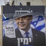 Workers hang a Likud party election campaign billboard featuring Prime Minister and Likud chairman Benjamin Netanyahu alongside opposition leaders, with the slogan “Right or Palestine,” on a building in Jerusalem, ahead of Israel’s upcoming general elections, October 14, 2026.