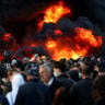 People gather near a fire as plumes of black smoke rise, amid an anti-government protest by students, in Tirana, Albania, October 14, 2026.