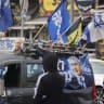 People walk past a vehicle displaying Likud campaign posters featuring Prime Minister Benjamin Netanyahu, in Jerusalem's Mahane Yehuda market, October 16, 2026