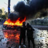 Protesters stand near a burning car during an anti-government protest by students in Tirana, Albania, October 17, 2026.