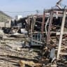 Illustrative: Komala party members look towards the debris is strewn from mangled structures following drone strikes on the Iranian Kurdish opposition Komala party's Sordash camp, which resulted in the death of a female party member and the injury of two others, April 15, 2026.
