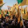 Supporters of the Popular Mobilisation Forces (PMF) chant slogans and wave flags at a rally celebrating the end of the U.S. military presence in Iraq on September 30, 2026 in Baghdad, Iraq. 
