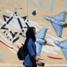 An Iranian woman walks next to an anti-Israeli mural on a street in Tehran, Iran, May 26, 2026