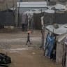 A child carrying an umbrella walks near displacement tents in Gaza City, Gaza Strip on October 18, 2026. During the first rainfall of the season in northern Gaza City, rain falls on tents sheltering displaced Palestinians amid the rubble of destroyed buildings.
