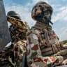 A Nigerian soldier sits in the back of a military escort vehicle along the Maiduguri-Damaturu highway on July 31, 2026. (illustrative)