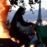 FILE PHOTO: A woman rides a bicycle past a burning barricade near the Tuileries Garden with the Eiffel tower in the background, amid clashes during a day of demonstrations against the cost of living and rising fuel prices in Paris as part of nationwide protests called by the "Yellow Vests" movement,