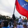 Dressed as the Statue of Liberty, a supporter of Venezuela's opposition holds up a Venezuelan flag at a demonstration to demand elections in 2027, in Caracas, Venezuela, October 22, 2026