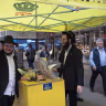 Shmuel Cohen (left) takes a break from wrapping tefillin with passersby in New York City's Diamond District on October 23, 2026. 