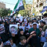 Syrians wave flags and hold portraits of people who were reportedly arrested during Israeli military incursions in southern Syria, as they protest near the United Nations building in Damascus, on October 23, 2026. 