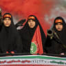 Women carrying weapons resembling shoulder-fired missiles ride in a truck during a pro-government National Army Day demonstration on April 17, 2026 in Tehran, Iran.