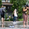 People cool off under the water sprays in Brussels, during a heatwave on June 19, 2026.