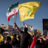 A man attending a ceremony marking the second anniversary of the assassination of Hezbollah leader Hassan Nasrallah and holding an Iranian and a Hezbollah flag on September 27, 2026 in Beirut, Lebanon.  