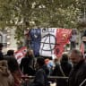 People on a tram stop holding a French flag with the inscription - revolution - during a demonstration against the high cost of living in southeastern France on October 24, 2026.  