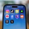  Instagram, TikTok, Snapchat, Kick, YouTube, Facebook, Twitch, Reddit, Threads and X applications are displayed on a mobile phone in this picture