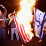 People burn the flags of the US and Israel in Tehran, Iran, April 8, 2026.