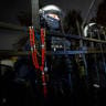 Police officers stand behind the fence with a rosary hanging on it as protesters gather outside the headquarters of Poland's Constitutional Court in Warsaw after police blocked access to the court building on 30 October, 2026.