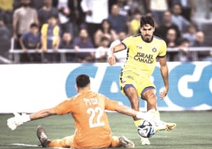 MACCABI TEL AVIV’s Dor Peretz shoots on Bnei Sakhnin ’keeper Mohammed Abu Nil in the yellow-and-blue’s 2-0 win in Israel Premier League action.