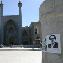  An Iranian woman walks past election campaign posters in Naghsh-e-Jahan square in Isfahan