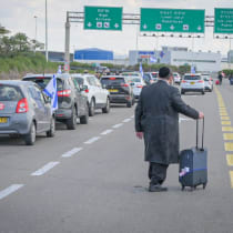 Man walks down the highway toward Ben-Gurion Airport as traffic is stopped during the judicial reform protests on March 9, 2023. 