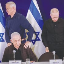  Minister-without-portfolio Benny Gantz walks behind Prime Minister Benjamin Netanyahu, as Defense Minister Yoav gallant takes his seat, at a recent news conference.
