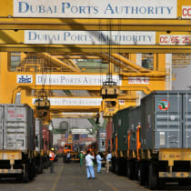  Foreign workers work as trucks queue inside Dubai's port in the United Arab Emirates February 14, 2006.