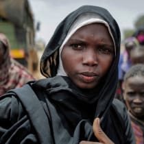   A Sudanese woman, who fled the conflict in Geneina in Sudan's Darfur region, is reunited with the rest of the family after she was relocated from makeshift shelters to a refugee camp in Ourang on the outskirts of Adre, Chad, July 25, 2023. 