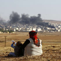 Turkish Kurds watch smoke rises over Syrian town of Kobani after an airstrike, as seen from the Mursitpinar border crossing on the Turkish-Syrian border in the southeastern town of Suruc in Sanliurfa province, October 18, 2014. A U.S.-led military coalition has been bombing Islamic State fighters wh
