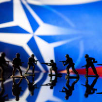  Army soldier figurines are displayed in front of the NATO logo and Russian flag colours background in this illustration taken, February 13, 2022.