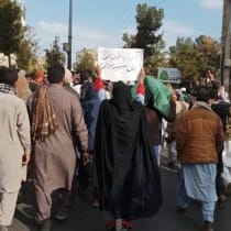  A woman in Zahedan holds a sign reading "What you’ve washed with blood is my dear soul."