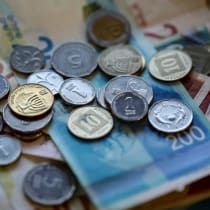  En esta ilustración fotográfica tomada el 9 de noviembre de 2021 se ven nuevos billetes y monedas de shekel israelí.