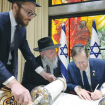  PRESIDENT ISAAC HERZOG writes the final letter in the Kiev Torah scroll, without the hand-guidance of a scribe.