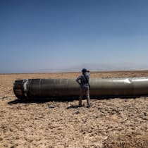  A man stands next to the apparent remains of a ballistic missile, as it lies in the desert near the Dead Sea, following a massive missile and drone attack by Iran on Israel, in southern Israel April 21, 2024 