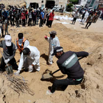 People work to move into a cemetery bodies of Palestinians killed during Israel's military offensive and buried at Nasser hospital, amid the ongoing conflict between Israel and Hamas, in Khan Yunis in the southern Gaza Strip, April 21, 2024.