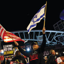  Un manifestante sostiene banderas estadounidenses e israelíes durante una protesta para pedir la liberación de los rehenes, Tel Aviv, 9 de marzo.