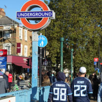  15 de octubre de 2023; Londres, Reino Unido; Un aficionado con una camiseta de la NFL sale de la estación de metro de Seven Sisters antes de un partido de las Series Internacionales de la NFL en el estadio del Tottenham Hotspur.