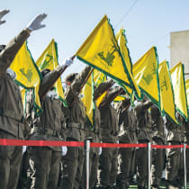  HEZBOLLAH OPERATIVES salute during the funeral of comrades killed in an Israeli strike, in Shehabiya, south Lebanon, April 17.