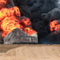  A man takes pictures of a raging fire at oil storage tanks a day after Israeli strikes on the port of Yemen's Houthi-held city of Hodeida on July 21, 2024. Yemen's Huthi rebels on July 21 promised a "huge" retaliation against Israel following a deadly strike on the port of Hodeida.