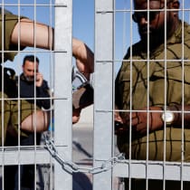 Soldiers lock a gate from the inside at Sde Teiman detention facility, after Israeli military police arrived at the site as part of an investigation into the suspected abuse of a Palestinian detainee, near Beersheba, in southern Israel, July 29, 2024.
