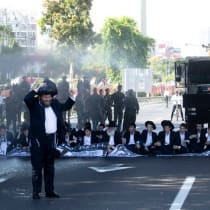  Agentes de policía en Bnei Brak, Israel, utilizan cañones de agua mientras hombres judíos ortodoxos haredi bloquean una carretera principal para protestar contra los esfuerzos para permitir que el Estado reclute a estudiantes haredi de yeshiva en el servicio militar, 2 de junio de 2024.