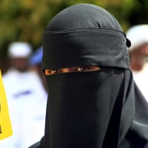  A woman holds a sign that shows the Rabaa hand gesture, which symbolizes support for the Muslim Brotherhood, during a march.  Sudan, May 22, 2015. 