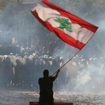  Un manifestante ondea la bandera libanesa frente a la policía antidisturbios durante una protesta en Beirut, Líbano, 8 de agosto de 2020 