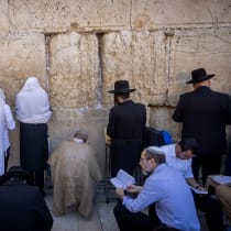  Jewish men pray during Tisha B'Av, at the Wall Western, in the Old City of Jerusalem, August 13, 2024