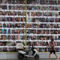  Un grupo de personas pasa junto a un muro con carteles de rehenes en Tel Aviv, Israel, el 18 de agosto de 2024.
