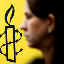  El logotipo de Amnistía Internacional se ve junto a la directora de Mujeres En Línea Luisa Kislinger, durante una conferencia de prensa para anunciar los resultados de una investigación sobre los abusos contra los derechos humanos cometidos en Venezuela durante las protestas contra el presidente