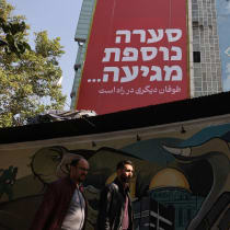  Iranians walk next to an anti-Israel billboard on a street in Tehran, Iran, October 27, 2024.