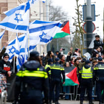  Manifestantes sostienen banderas palestinas e israelíes mientras se reúnen frente al Museo Nacional del Holocausto el día de su inauguración, en Ámsterdam, Países Bajos, 10 de marzo de 2024.