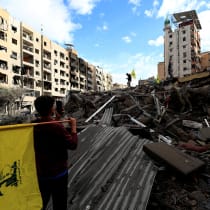  People carry Hezbollah flags at a damaged site in Beirut's southern suburbs, after a ceasefire between Israel and Hezbollah took effect, in Beirut, Lebanon November 27, 2024.