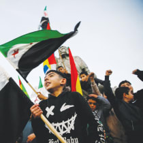 CHILDREN HOLD flags next to a sculpture of Druze warrior Sultan Pasha al-Atrash after Syrian rebels announced the ousting of president Bashar Assad, in the Druze village of Majdal Shams, Golan Heights, earlier this month.