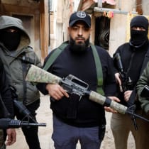  Varios hombres armados permanecen de pie durante el funeral del palestino Ribhi Shalabi, muerto en enfrentamientos con las fuerzas de la Autoridad Palestina, en el campo de Yenín, en Cisjordania, el 10 de diciembre de 2024.